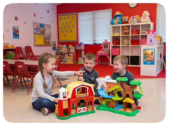 Children playing with a toy farm in a classroom